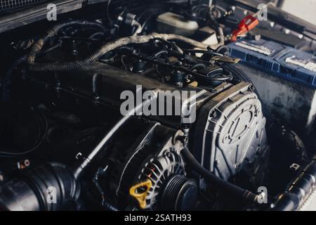 Primo piano del motore di un'auto con componenti e cablaggi visibili, per la riparazione o il controllo Foto Stock