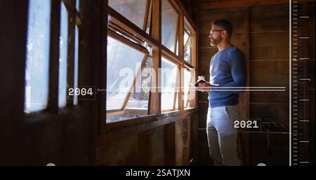 Immagine dell'elaborazione dei dati finanziari sull'uomo caucasico che prende appunti e guarda attraverso la finestra Foto Stock