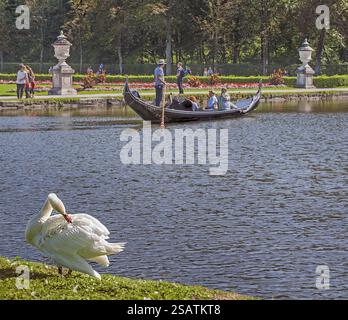 Gondola, cigno e visitatori nel Parco del Castello di Nymphenburg, Monaco, alta Baviera, Baviera, Germania, Europa Foto Stock