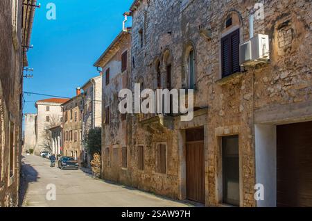 Una strada residenziale di case storiche in pietra nel villaggio di Svetvincenat, nell'Istria centrale, Croazia. Alcune sono tenute male, altre rinnovate Foto Stock