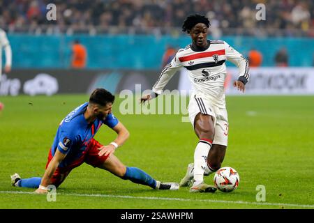 Bucarest, Romania. 30 gennaio 2025. Il Kobbie Mainoo (R) del Manchester United si confronta con Mihai Popescu della FCSB durante la partita di calcio UEFA Europa League tra il Manchester United e la FCSB a Bucarest, Romania, 30 gennaio 2025. Crediti: Cristian Cristel/Xinhua/Alamy Live News Foto Stock