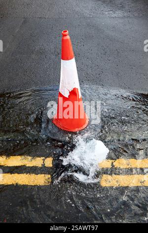 cono di traffico accanto all'acqua dall'inondazione proveniente dalla rete principale di acqua dolce che va a drenare le strade di belfast, irlanda del nord, regno unito Foto Stock