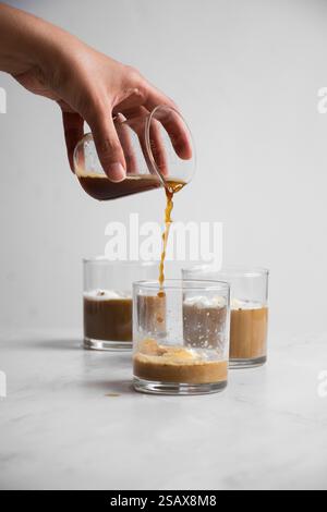 Caffè versato su tre bicchieri con gelato alla vaniglia Foto Stock