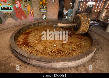 Tradizionale mulino in pietra per frantumare il maguey per la produzione di Mezcal a Oaxaca in Messico. Foto Stock