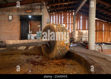 Tradizionale mulino in pietra per frantumare il maguey per la produzione di Mezcal a Oaxaca in Messico. Foto Stock