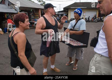 Un uomo che vende falsi orologi Rolex e altri marchi di stilisti in un mercato di strada ai turisti tedeschi. Mercato di strada degli orologi di marca Ubud, Isola di Bali in Indonesia Sud-est asiatico anni '2006 2000 HOMER SYKES Foto Stock