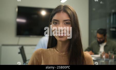 Donna caucasica ritratto d'affari ispanico imprenditrice donna datore di lavoro investitore team leader ragazza che gira testa a fotocamera sorridente felice Foto Stock
