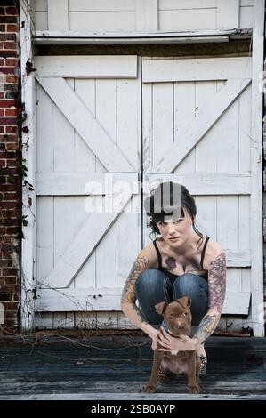 Bella giovane donna con il suo cucciolo di pit Bull Foto Stock