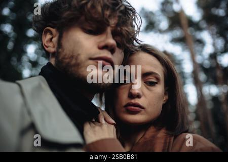 Primo piano introspettivo di una coppia in una luce soffusa all'interno di un ambiente forestale Foto Stock
