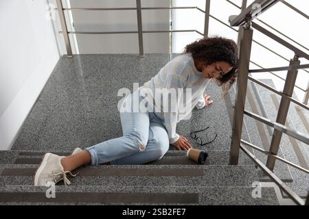 Donna ferita sulle scale dell'edificio dopo l'autunno. Incidente pericoloso Foto Stock