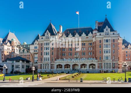 Un grande edificio in mattoni con una bandiera in cima. L'edificio è in una città. Ci sono persone che camminano intorno all'edificio Foto Stock
