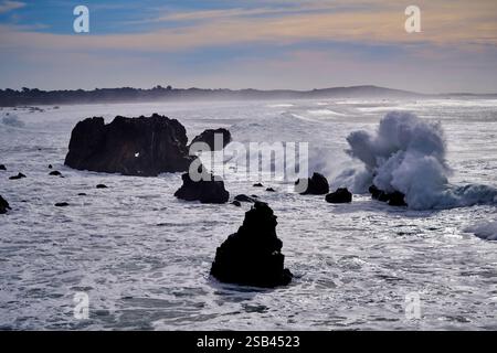 le onde di tempesta si schiantano contro le rocce offshore Foto Stock