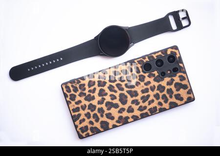 smartphone e orologio intelligente su sfondo color crema Foto Stock