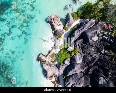 Prospettiva aerea della spiaggia Anse Source D'Argent a la Digue, Seychelles, che mostra acque turchesi chiare, sabbia bianca e grandi formazioni rocciose di granito Foto Stock