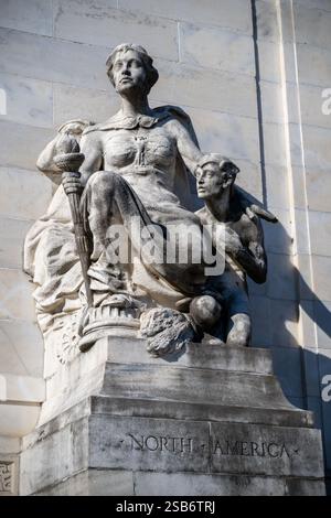 North America Sculpture Organization of American States Washington DC // WASHINGTON DC — la scultura allegorica in marmo "North America" di Gutzon Borglum si trova all'ingresso destro dell'Organization of American States Building. Creata nel 1910, la scultura raffigura una figura femminile drappeggiata che tiene in mano una torcia, accompagnata da un giovane vigile. La scultura si abbina al "Sud America" sul lato opposto, fiancheggiando le griglie d'ingresso in bronzo. Foto Stock
