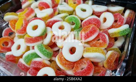 Anelli in gelatina colorati con zucchero. Caramelle in gelatina in primo piano. Reparto dolciumi nel negozio. Caramelle da masticare in gelatina. Dolci. Anelli di caramelle Foto Stock