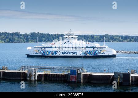 Vancouver Columbia Britannica Canada, 24 luglio 2024: Traghetto per piccoli veicoli con opere d'arte delle prime Nazioni in arrivo al terminal per scaricare il passeggero a piedi e il tour Foto Stock