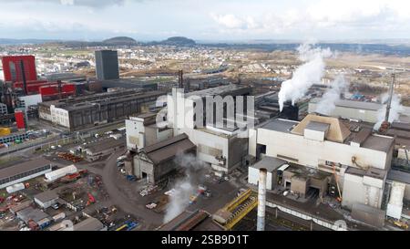 Vista aerea ad alto angolo di Esch-sur-Alzette, Lussemburgo, che mostra una grande fabbrica di acciaio con ciminiere di fumo che emettono vapore, circondata da edifici industriali, magazzini e moderni sviluppi urbani. Foto Stock