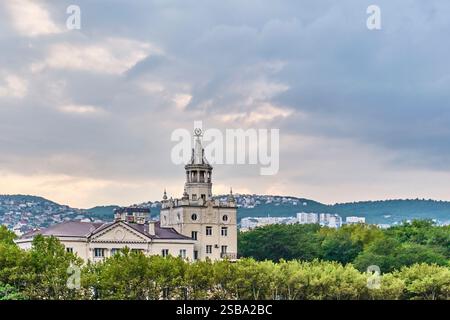 Elegante edificio in stile Impero stalinista a Novorossijsk, Russia, costruito nel 1954. La facciata presenta intricati dettagli in stucco, tra cui rosette, carrucole, Foto Stock