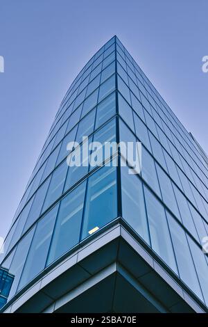 Vista ad angolo basso di un moderno grattacielo di vetro, con la sua facciata a griglia e le finestre riflettenti su un cielo azzurro. L'edificio è S. Foto Stock