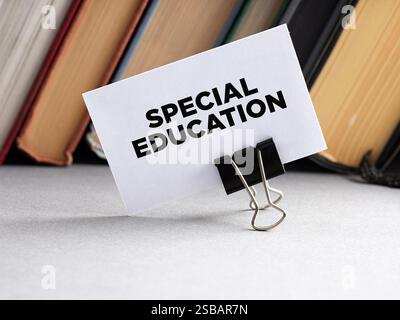 Il messaggio istruzione speciale scritto su un biglietto da visita con sfondo di libri. Istruzione speciale studenti disabili con disabilità di apprendimento. Foto Stock