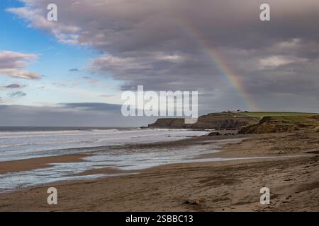 Arcobaleno che sorvola Widemouth Bay in Cornovaglia Foto Stock
