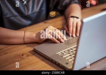 primo piano delle mani di una donna che digita un laptop sulla scrivania di legno, concetto di marketing digitale, lavoro remoto, creazione di contenuti Foto Stock