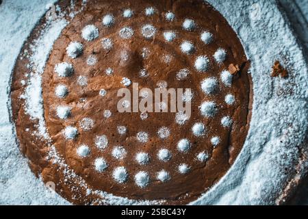 Sfondo con trama a torta. Torta fatta in casa cosparsa di zucchero a velo da vicino, vista dall'alto. Foto di alta qualità Foto Stock