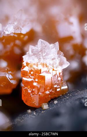 Calcite bianca su vanadinite arancione su baryte. Esemplare dal Marocco. Micro Photography primi piani estremi. fotografia al microscopio con cristalli minerali Foto Stock