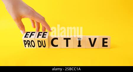Simbolo efficace e produttivo. Mano d'affari trasforma un cubo e cambia la parola produttiva in efficace. Bellissimo sfondo giallo. Affari e. Foto Stock