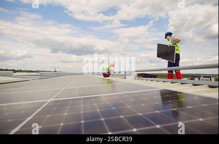 Gli ingegneri stanno installando o riparando pannelli solari sul tetto. Foto Stock