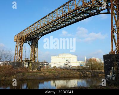 Ponte industriale rustico con sfondo blu e tranquillo fiume sottostante. Foto Stock