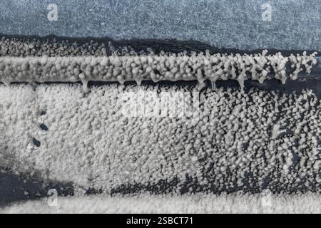 lo strato di ghiaccio si è formato sulla portiera dell'auto in caso di pioggia gelida invernale sulla strada Foto Stock