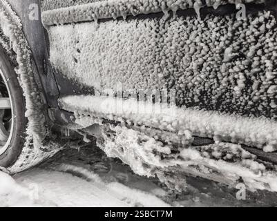 lo strato di ghiaccio si è formato sulla portiera dell'auto in caso di pioggia gelida invernale sulla strada Foto Stock