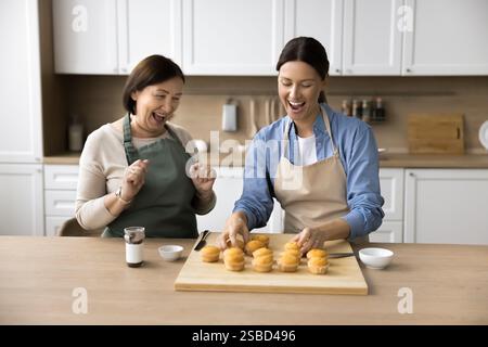 Madre e figlia cucinano insieme dessert in cucina Foto Stock
