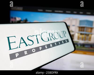 In questa immagine, uno smartphone con il logo della società americana REIT EastGroup Properties Inc. È visibile sullo schermo davanti al sito Web. Foto Stock