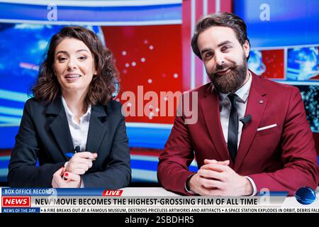 Nuovo annuncio televisivo di film negli studi di stampa, un team di giornalisti dei media parla di film che infrangono record e classifiche al botteghino. I relatori lavorano nel segmento dell'intrattenimento dal vivo. Foto Stock