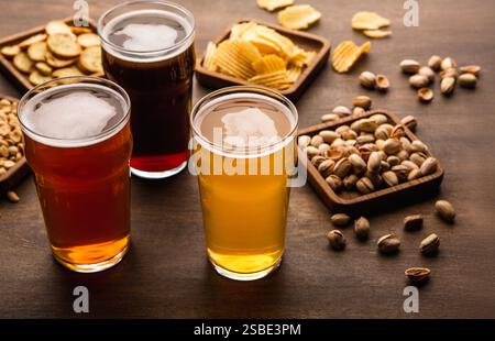 Tavolo per la compagnia di amici. Spuntini croccanti e diversi tipi di birra in bicchieri Foto Stock