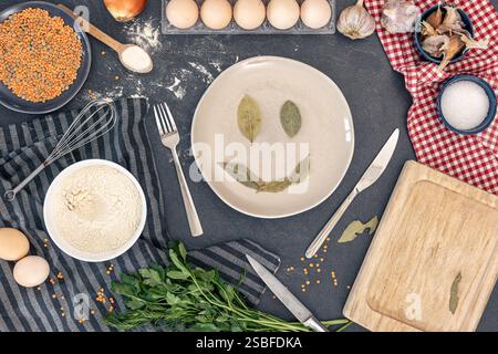 Background di cottura. Ingredienti per cucinare. Uova, cereali, aglio, spezie, prezzemolo. Foto Stock