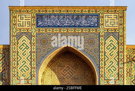 Una vista ravvicinata di un arco splendidamente decorato caratterizzato da intricate piastrelle e calligrafia, che mostra colori vivaci e motivi geometrici tipici Foto Stock