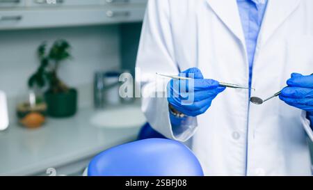 Vista ravvicinata di un dentista che prepara gli strumenti in una moderna clinica odontoiatrica Foto Stock
