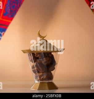 Una lanterna dorata del Ramadan piena di datteri con una mezzaluna Foto Stock