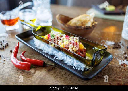 Tartare di manzo dal Black Angus. Tuorlo d'uovo, cetriolo sottaceto, scalogno, cipolla perlata, coriandolo e semi di senape. Cibo italiano delizioso e salutare servito Foto Stock