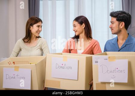 gruppo di amici che tiene in mano vestiti in una donazione box.community sostegno e donazione di beneficenza Foto Stock