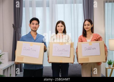 gruppo di amici che tiene in mano vestiti in una donazione box.community sostegno e donazione di beneficenza Foto Stock