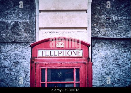 Vecchia cabina telefonica rossa K6 in disuso accanto all'ufficio postale chiuso Foto Stock