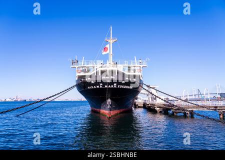 La nave da crociera Hikawa Maru attraccata nel porto di Yokohama, in Giappone, sotto un cielo luminoso, catturando la storica nave e l'atmosfera del lungomare. Foto Stock