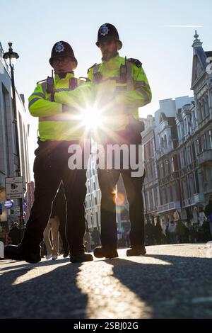 Durante le celebrazioni del capodanno cinese a Londra, due ufficiali della polizia metropolitana si sono incontrati sulla Shaftsbury Avenue in una giornata di sole con cielo e cieli blu. (143) Foto Stock
