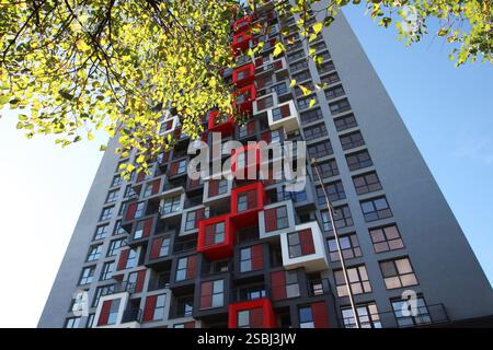 Un edificio molto alto caratterizzato da numerose finestre e balconi multipli sparsi in tutta la sua struttura per vari usi e design Foto Stock