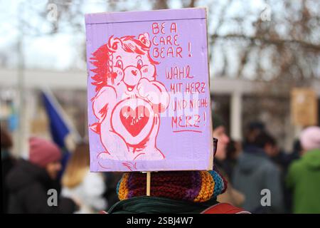 Proteste und Gegenproteste in der Göttinger Innenstadt - Demoplakat mit der Aufschrift: BE A CARE BEAR - WÄHL MIT HERZ UND NICHT MERZ - Abbildung: Bär mit rotem Herz und der Aufschrift: DIE LINKE - Deutschland, GER, DEU, Germania, Göttingen, 01.02.2025 - Unter dem Titel Versammlungsfreiheit statt Extremismus versammelten sich ca. 450 sogenannte Querdenker in der Göttinger Innenstadt vor dem Hauptbahnhof zu einer Protestkundgebung. In Sichtweite der Querdenker-Szene kamen tausende Menschen auf einer Grünfläche zum Gegenprotest zusammen, um gegen die Querdenkerbewegung und gegen rechte Tendenzen Foto Stock